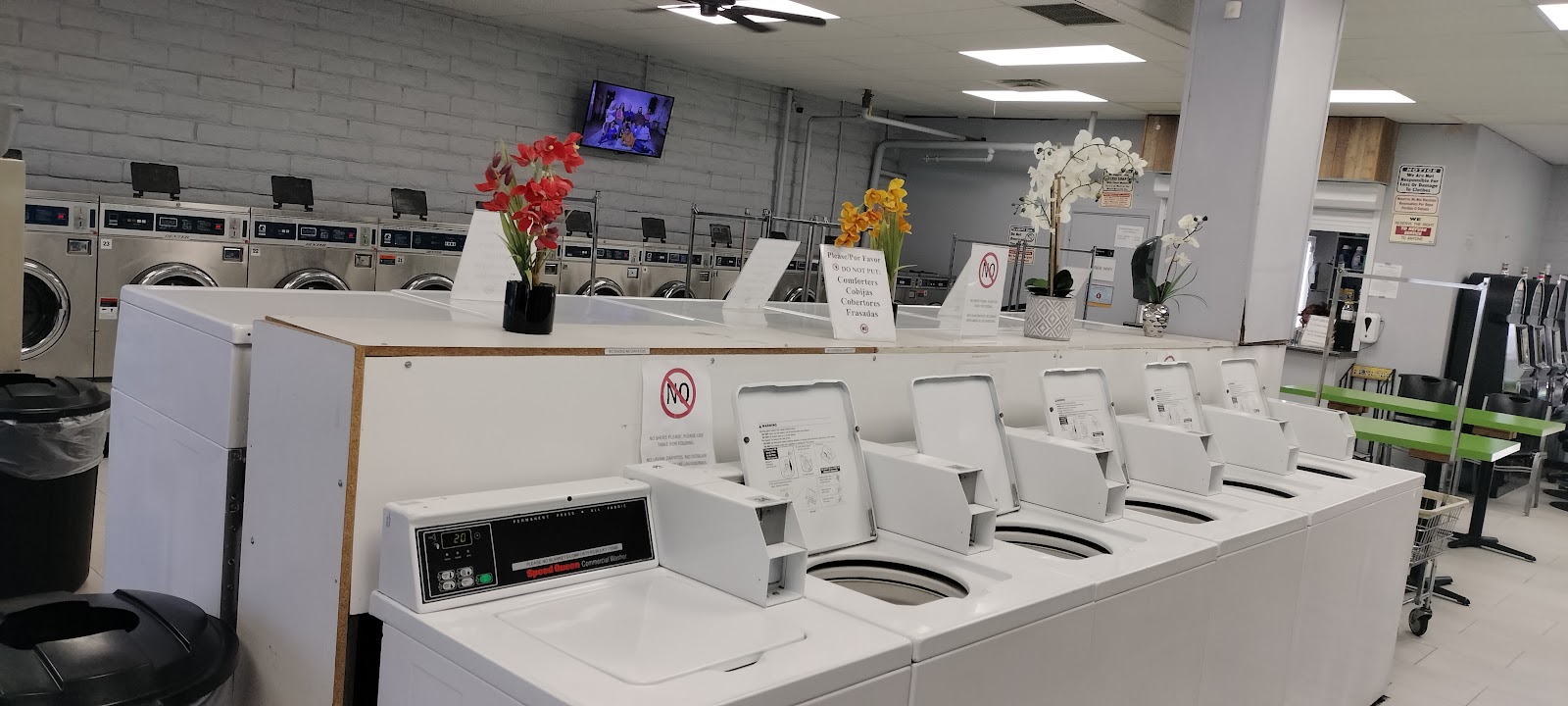 Row of Speed Queen top-load washers with decorative flowers